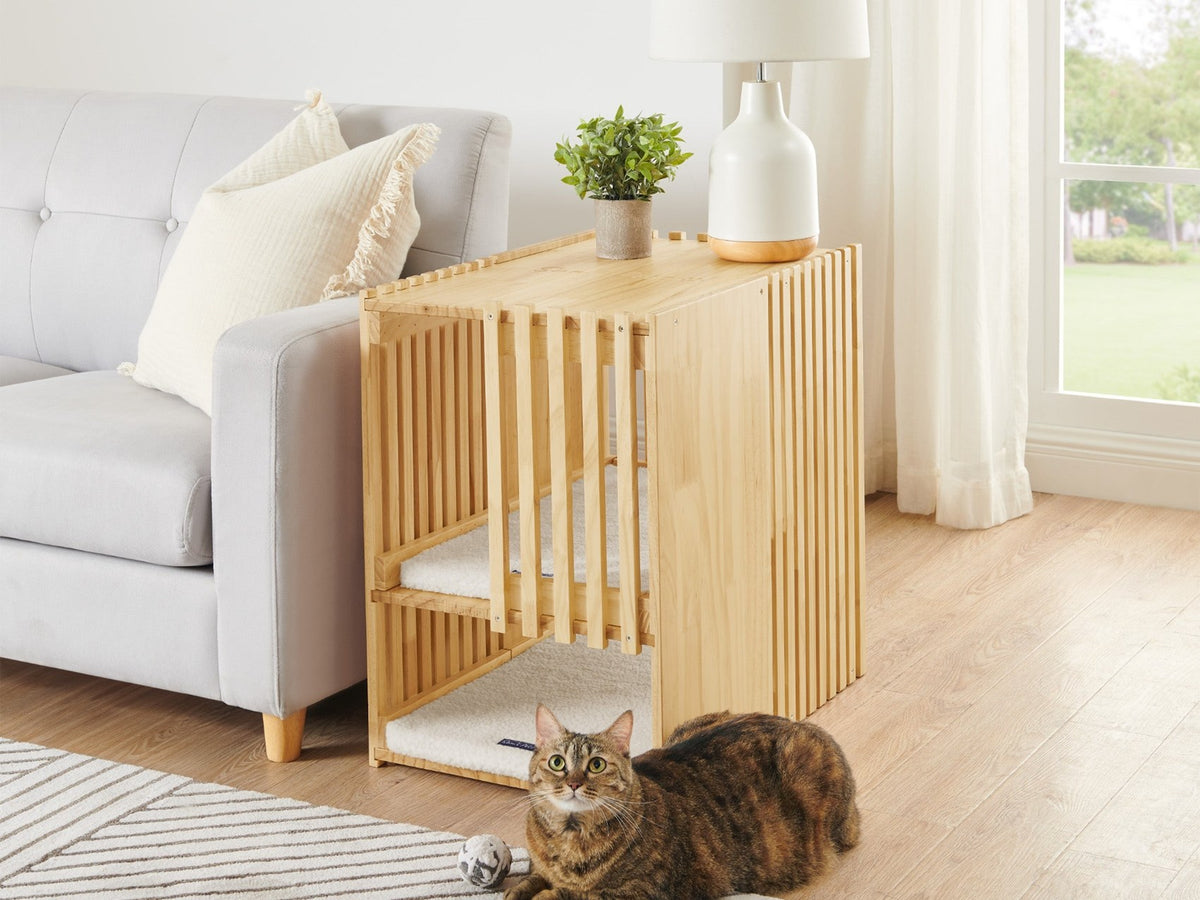 Sam's Pets Yves cat tower used as an end table beside a sofa, with a tabby cat on the rug